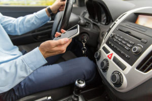 Driver using a smartphone while driving, illustrating distracted driving in Johnson City.