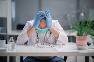 saddened doctor sitting next to a table