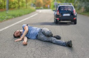 man lying on the road after a hit-and-run car accident