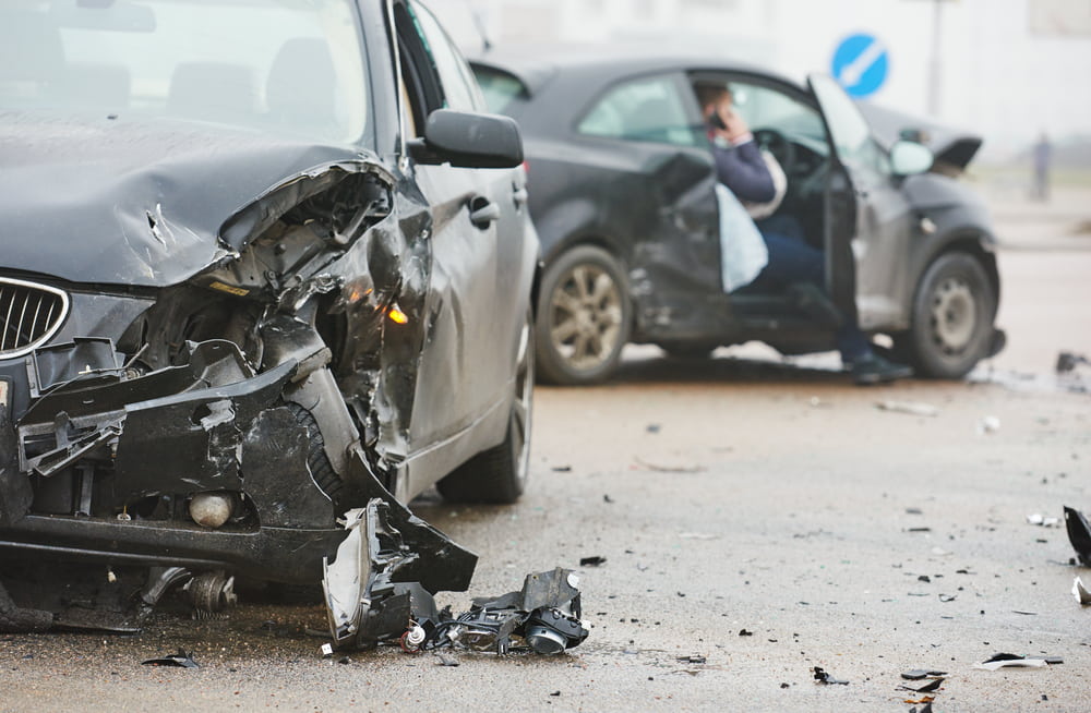 two black cars with damage after crash